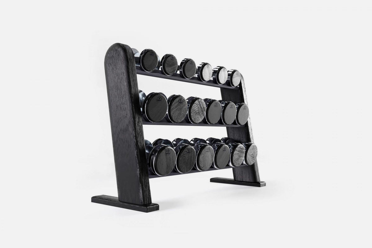 Three-tier black-stained wood rack holding nine pairs of nickel-plated dumbbells with dark end caps