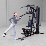 Body-Solid G6B gym in use with leg kickback