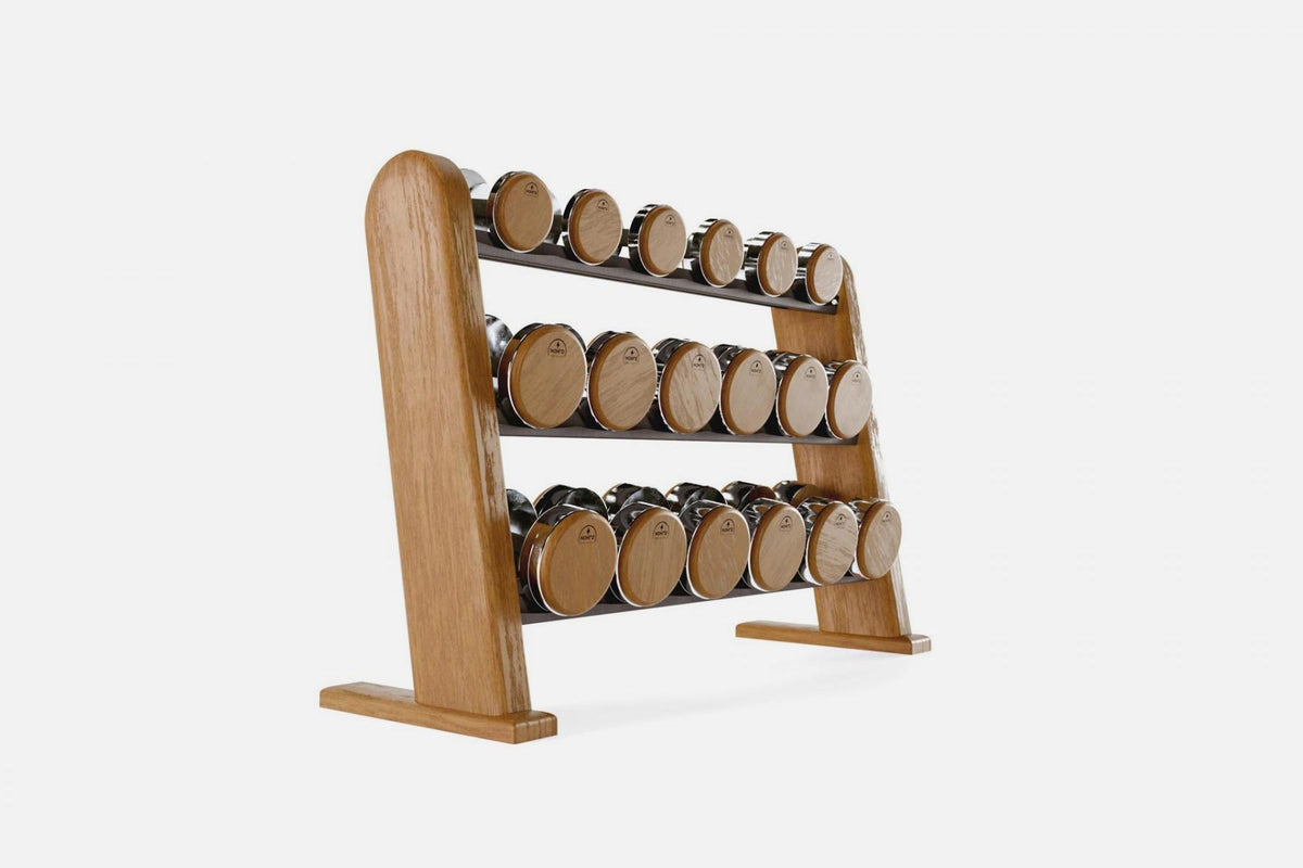 Three-tier cherry-wood rack holding nine pairs of nickel-plated dumbbells with warm golden wood end caps