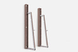 Two wall-mounted squat racks in medium-brown wood, one folded shut and one opened to a silver ladder