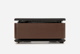 Front view of a dark reddish-brown storage bench with the padded lid raised and resistance bands visible inside