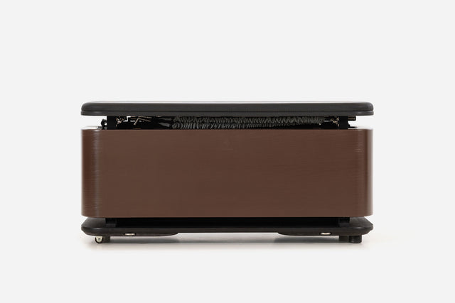 Front view of a dark reddish-brown storage bench with the padded lid raised and resistance bands visible inside